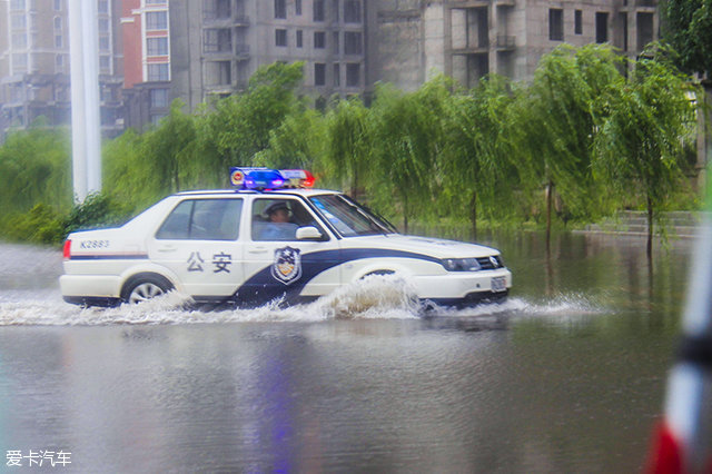 鄂尔多斯因下雨道路积水,一辆警车正在积水中赶往需要加派警力的地点